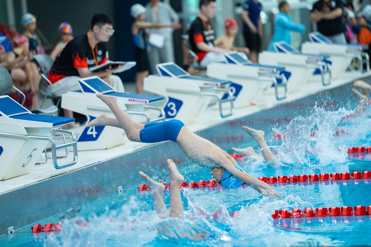 Young swimmers diving into a competition pool